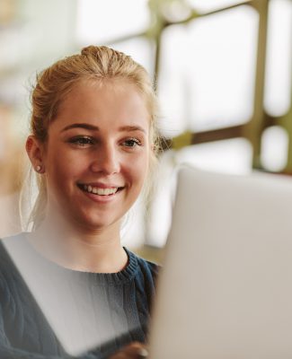 Girl studying with laptop in university class